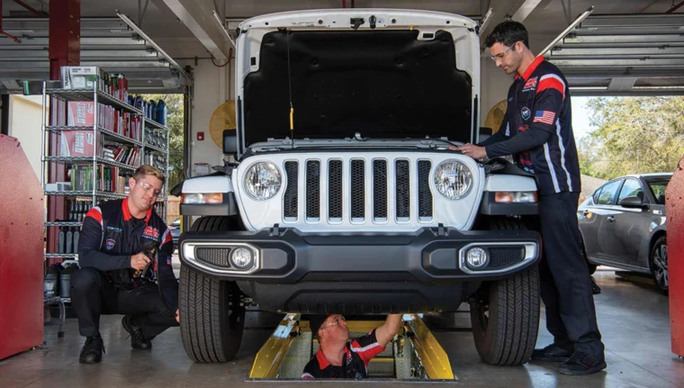 Grease Monkey technicians working as a team in a service bay.